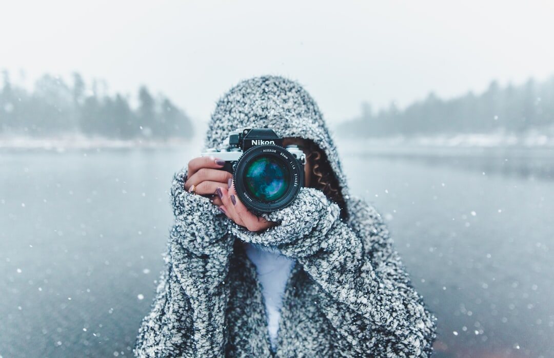 Danish male documentary photographer holding a camera outdoors
