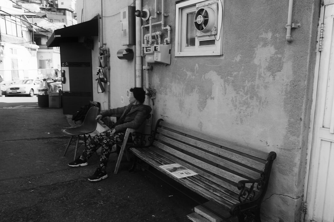 elderly man reading newspaper on bench